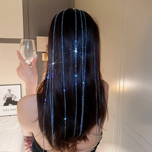 Detail of luxury long rhinestone fringe hair chains sparkling in dark hair for women