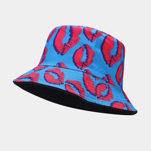 Dettaglio di un cappello a secchiello blu reversibile con stampa di labbra rosse