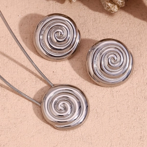 Macro detail of silver spiral pendant necklace and matching textured stud earrings set