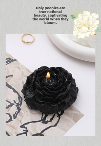 Detail of black peony flower scented candle featuring realistic petals and a burning flame