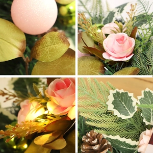 Christmas wreath with pink roses, green leaves, gold balls, and pine cones for door decor