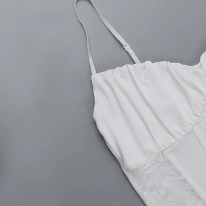 Detail of white lace patchwork and ruffled fabric on a sexy spaghetti strap top
