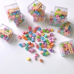 Macro shot of assorted colorful mini floral and animal hair clips in a gift box