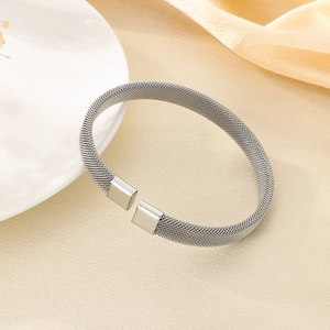 Dettaglio ravvicinato di un bracciale aperto a maglia d'argento con finitura terminale quadrata