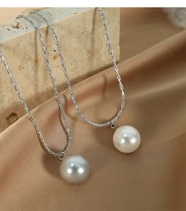 Detailed close-up of elegant silver pearl necklaces on stone and silk background