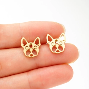 Golden French Bulldog stud earrings in hollowed stainless steel design held by hand