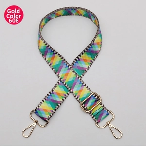 Close-up of woven bag strap with colorful diamond pattern and gold metal hooks