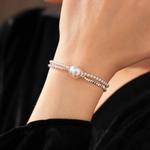 Detail of a double-layer pearl bracelet with silver faceted beads on a model wrist