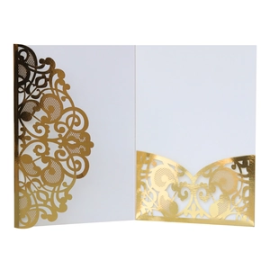 Detail of white laser-cut invitation card with elegant gold foil hollow patterns