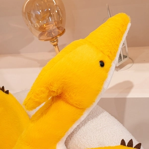 Detailed close-up of soft yellow plush pterodactyl toy showing premium fuzzy material