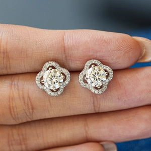 Moissanite lucky four-leaf clover stud earrings in S925 silver shown on a finger