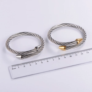 Close-up of dual-tone 6mm cable wire bracelets with ruler showing 6.5cm diameter