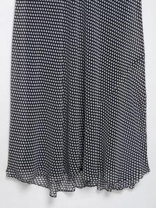 Detail of a lightweight black and white polka dot summer dress showing fabric texture