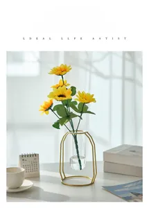 Detail of hydroponic glass vase with golden metal stand and a yellow sunflower
