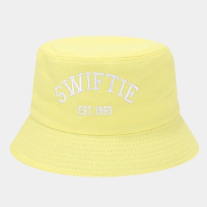 Detailed close-up of white SWIFTIE EST. 1989 embroidery on bright yellow canvas bucket hat