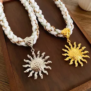 Bohemian sun pendant necklace with woven cotton rope in gold and silver finish