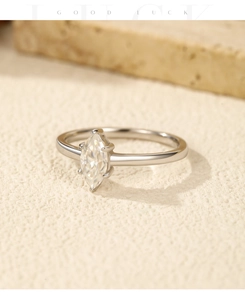 Macro view of marquise cut moissanite ring in silver band on stone background