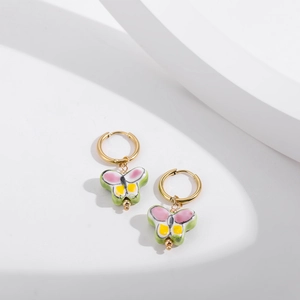 Detail of colorful butterfly enamel charms on gold stainless steel hoop earrings