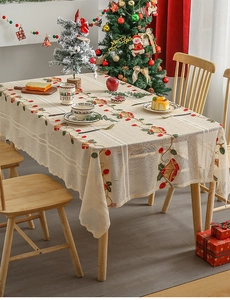 Detailed close-up of Christmas embroidery with bells and cherries on a linen tablecloth