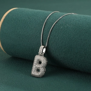 Close-up of silver letter B pendant with micro-pave zircons on a box chain necklace
