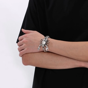 Close-up of a silver scorpion cuff bracelet in punk style worn on a male wrist