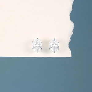 Macro detail of oval cut white zircon stud earrings in 925 sterling silver prong setting