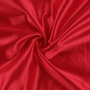 Détail du satin rouge brillant montrant la texture plissée et le drapé soyeux du tissu