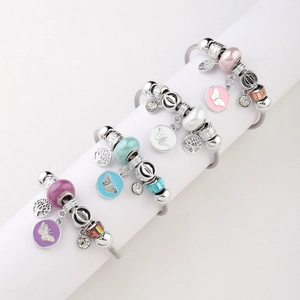 Detailed view of colorful beaded bracelets with butterfly charms and glass beads on a stand