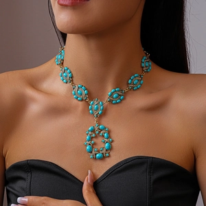 Collier vintage doré avec pendentifs yeux en résine turquoise et strass sur mannequin