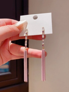 Macro view of long tassel earrings with purple cubic zirconia and dangling chains