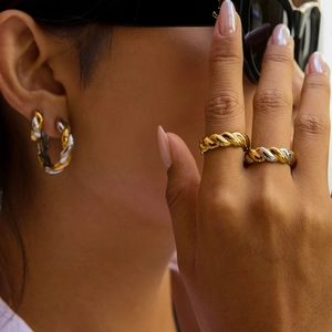 Close-up of mixed metal twisted rope rings and hoop earrings on model in gold and silver