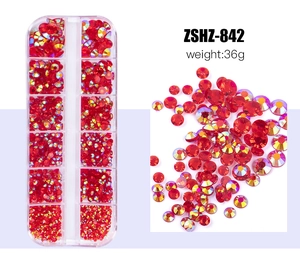 Macro detail of red flatback rhinestones in a 12-grid storage box for nail art DIY