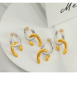 Macro detail of geometric C-shape layered link earrings in gold and silver finish