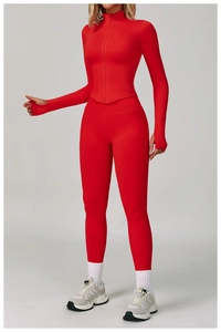 Détail de l'ensemble de yoga rouge avec poignets passe-pouce et veste zippée ajustée