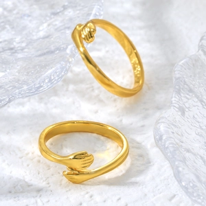 Macro shot of gold-plated hugging hands rings with polished texture and smooth curves