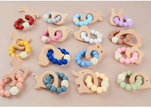 Flat lay of colorful silicone beaded teething rings with various beech wood animal shapes