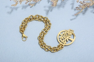 Detailed macro view of gold double-layer chain bracelet featuring tree of life charm