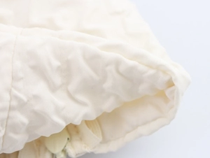 Gros plan détaillé sur la texture du tissu blanc matelassé avec fermeture éclair