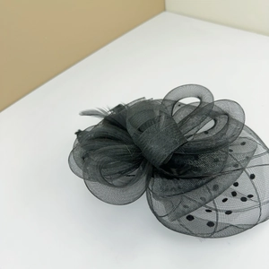 Close-up of vintage black mesh fascinator with delicate feathers and polka dot veil detail