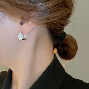 Side view of silver teardrop hoop earring with cat eye stone on model's ear