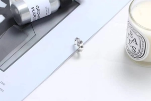 Detail view of silver heart crying face ring with S925 engraving on a white background