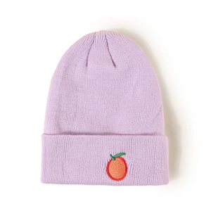 Détail d'un bonnet en maille violette avec broderie de fruits orange pour enfants