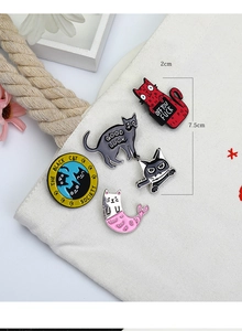 Detailed view of colorful cat enamel pins attached to a white canvas bag accessory