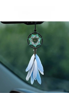 Detail of dreamcatcher car mirror pendant with blue feathers and silver deer charm