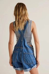 Back view of loose denim overalls featuring functional rear pockets and rolled-up hem detail