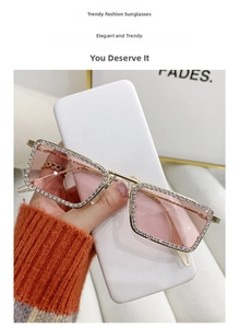 Detalle de gafas de sol cuadradas sin montura con pedrería dorada y cristales degradados rosa