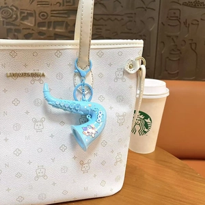 Creative blue saxophone keychain charm attached to a stylish white tote bag accessory