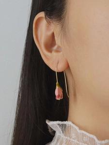 Close-up of pink tulip enamel flower earrings worn by a model in French vintage style