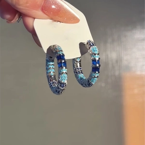 Detailed close-up of hoop earrings with dark and sky blue zirconia stones in a vintage style