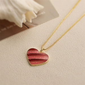 Collier doré avec pendentif cœur ailé à rayures rouges scintillantes et chaîne maille